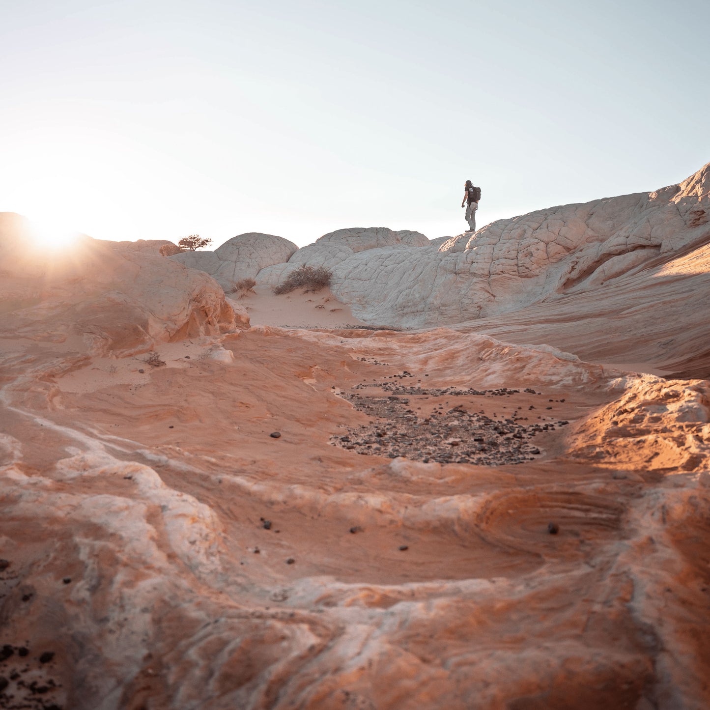 A low shot looking upward, a person walking on the ledge of a rough terrain