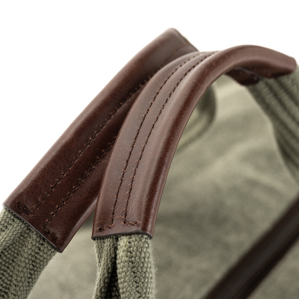 
                  
                    Robust duffel handles are detailed with full-grain Dakota leather
                  
                